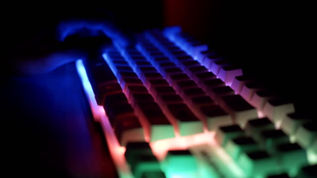Nahansicht-von-Esport-Sportler,-Gamer-spielen-auf-RGB-Tastatur-mit-bunten-Lichtern