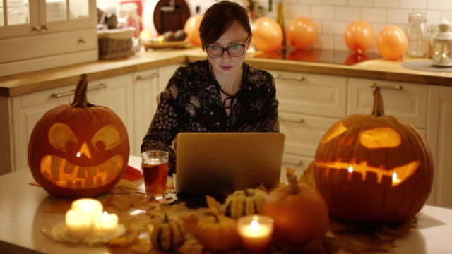 Mujer-con-portátil-en-medio-de-decoraciones-de-Halloween