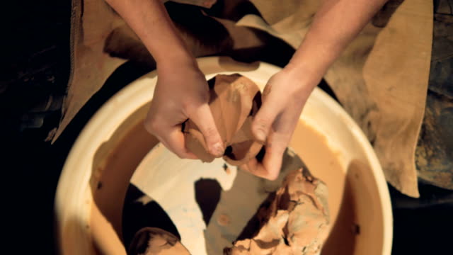 A-close-view-on-potters-hands-kneading-clay.