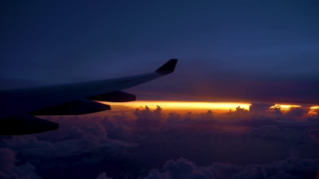ESPACIO-de-la-copia:-Ala-de-aeroplano-grande-volando-a-través-del-hermoso-cielo-púrpura-y-naranja.