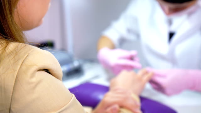 Verschwommene-Kosmetikerin-sorgfältigen-und-genauen-entfernen-Nagelhaut-mit-polnischen-Maschine