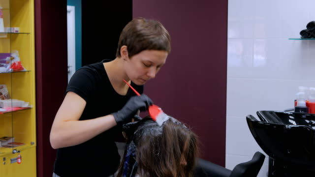 Professioneller-Friseur-färben-Haare-der-Frau-Client-im-studio