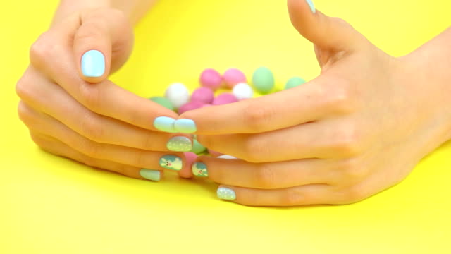 Manicured-hands-and-multicolored-sweet-candies.