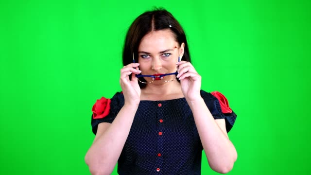 Grüner-Hintergrund,-Chromeakey.-Porträt-einer-sexy-Brünette-Frau-mit-roten-Lippen,-in-stilvollen-Gläsern,-Brille,-bewegt-sich-erotisch,-spielerisch,-sexuell-Blick-in-die-Kamera,-posiert-im-studio