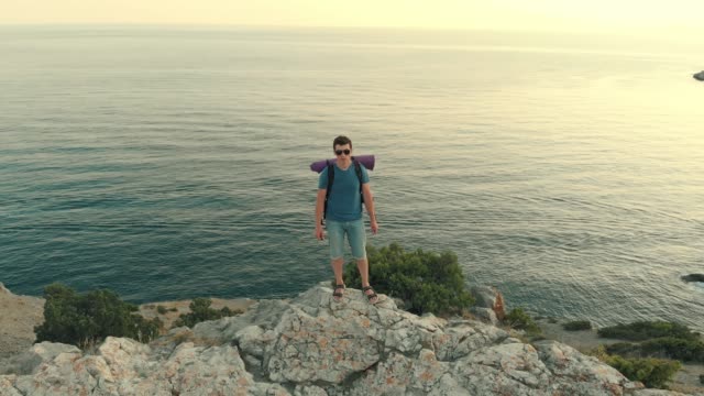 Man-with-backpack-standing-on-the-rock