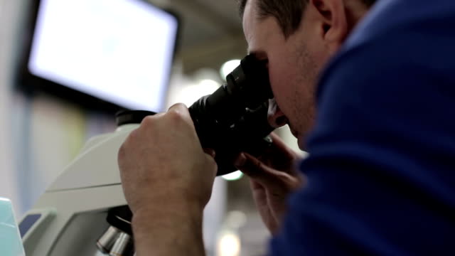 Médico-en-los-trabajos-de-laboratorio-con-un-microscopio