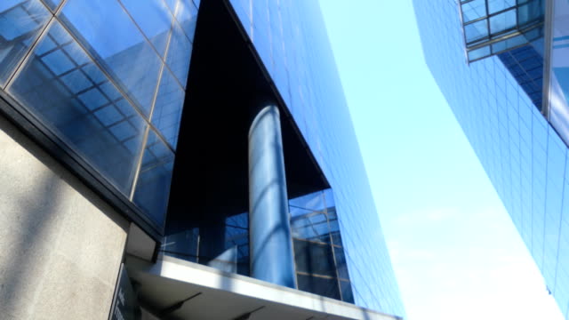 Empresaria-camina-en-Highrise-vidrio-oficinas