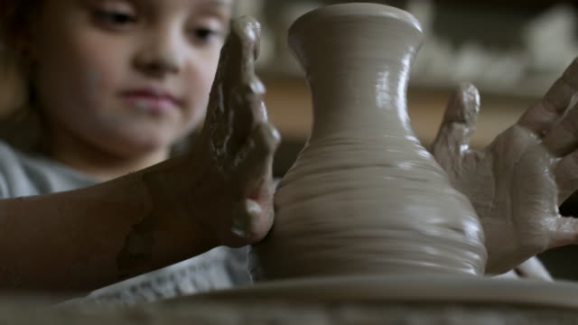 Niedliche-Mädchen-werfen-Vase-auf-der-Töpferscheibe