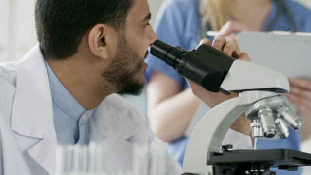 Científico-hombre-negro-usando-microscopio