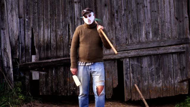 Man-in-Halloween-mask-with-a-rake-and-a-knife