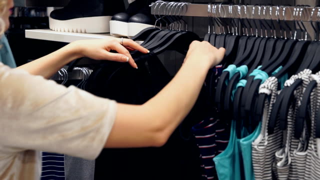 Frauen-die-Wahl-Kleidung-in-Einkaufszentrum-oder-Bekleidungsgeschäft-einkaufen.