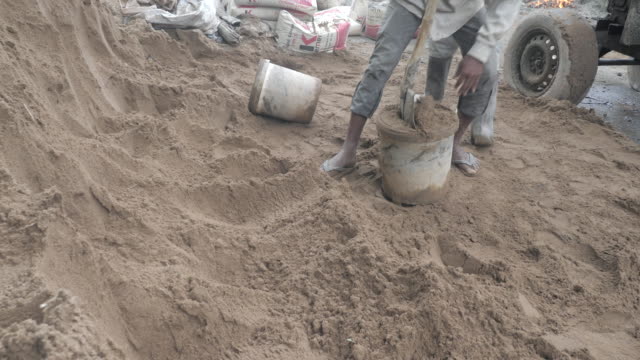 Using-a-shovel-to-put-sand-into-a-bucket-(-close-up)