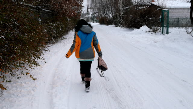 Erwachsene-Frau-macht-Spaß-zu-Fuß-auf-einer-verschneiten-Straße.