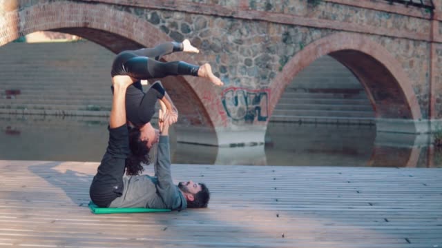 Beautiful-couple-practicing-acro-yoga-in-the-morning