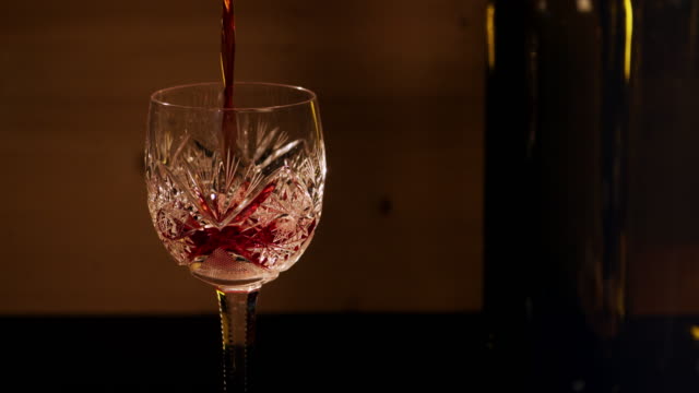 Rotwein-wird-in-ein-Glas-gegossen.
