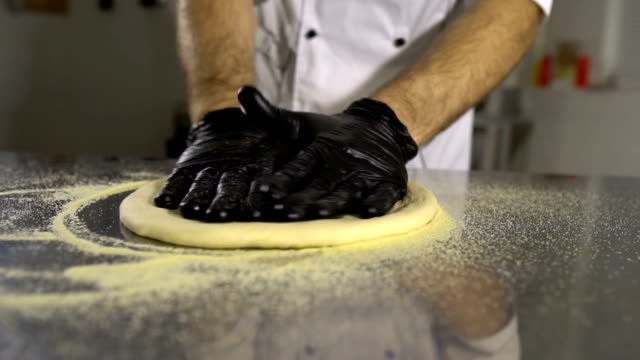 Cook-in-the-kitchen-preparing-pizza-dough.-A-man-prepares-pastries
