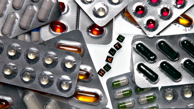 Diferentes-pastillas-en-un-blister-gire-y-en-el-centro-está-la-inscripción-salud