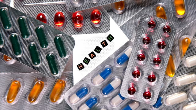 Verschiedene-Pillen-in-einer-Blisterverpackung-drehen-und-in-der-Mitte-befindet-sich-die-Inschrift-Gesundheit