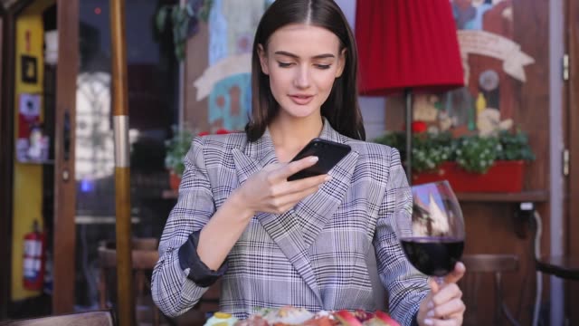 Beautiful-Woman-Taking-Food-Photos-On-Mobile-Phone-At-Restaurant