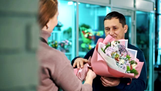 A-man-takes-a-bouquet-of-flowers-from-a-florist.
