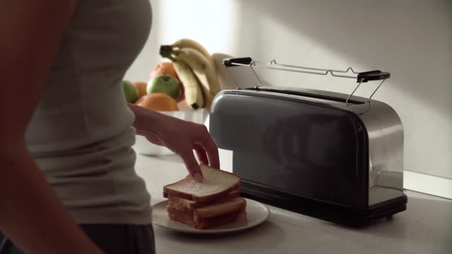 Frühstück.-Frau,-setzen,-schneiden-Brot-im-Toaster-Closeup