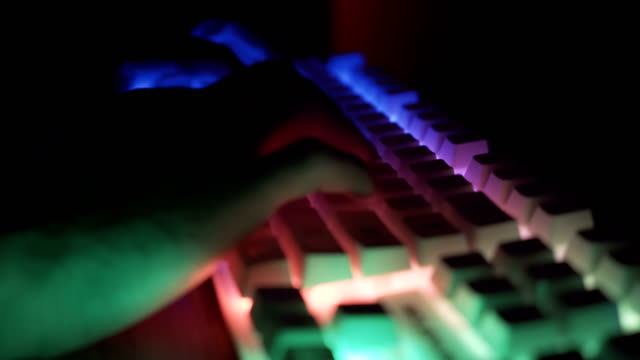 Seitenansicht-der-männlichen-Hände-arbeiten-auf-der-Tastatur-mit-leuchtenden-Tasten