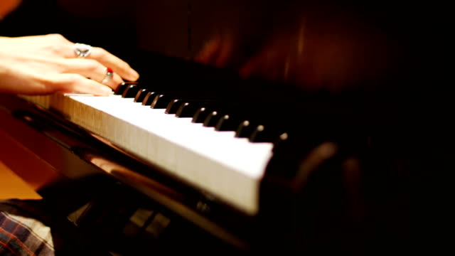 Close-up-of-woman-playing-a-piano