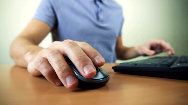 Close-up-of-hands-typing-on-computer-keyboard-and-mouse