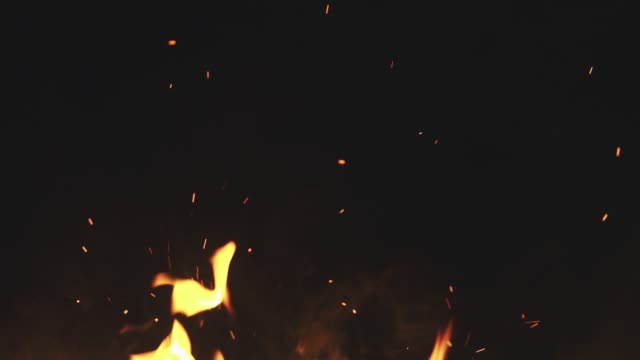 Feuer-Flammen-mit-Funken-vom-Lagerfeuer-auf-schwarzem-Hintergrund
