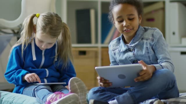 Mädchen-spielen-auf-digitale-Tablets
