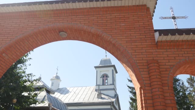 Iglesia-ortodoxa,-la-puerta-de-entrada-al-territorio-de-la-iglesia-ortodoxa,-el-arco-y-soleada-mañana,-árboles-verdes