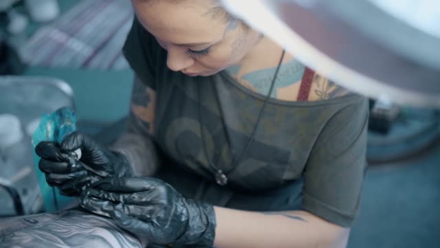 mujer,-un-artista-del-tatuaje,-hace-un-tatuaje-en-el-salón.