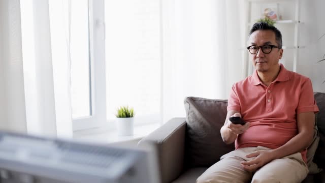 man-with-remote-control-watching-tv-at-home