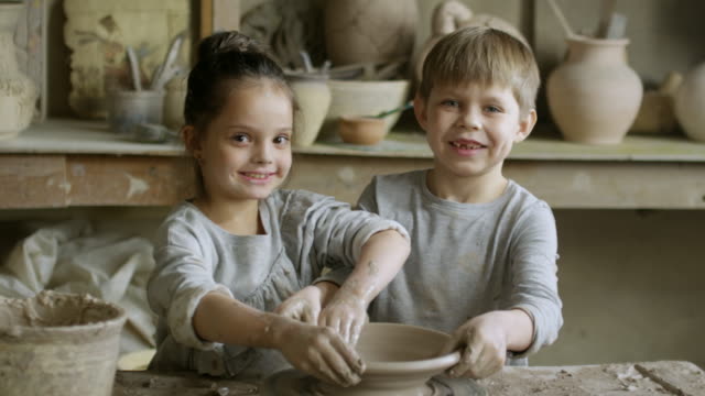Niños-lindos-hacer-cerámica-y-posando