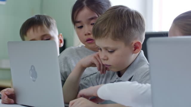 Schulkinder,-die-Aufgabe-auf-Laptop-Computer