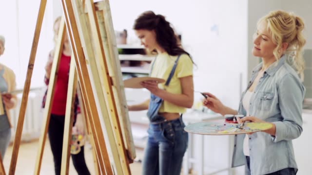 students-with-easels-painting-at-art-school