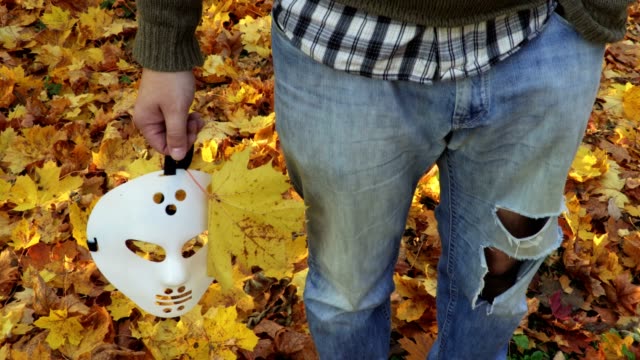 Hombre-con-scary-Halloween-Máscara-y-hojas-de-otoño