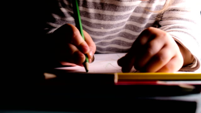 Kleines-Mädchen-zieht-grünen-Bleistift-auf-einem-Blatt-Papier-Nahaufnahme