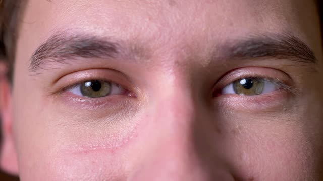 Close-up-konzentriert-Kaukasischen-Männchen-seine-Brille-entfernen-und-auf-der-Suche-direkt-mit-grünen-ruhigen-Augen