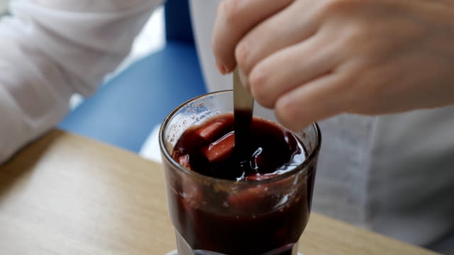 woman-in-a-cafe-stirs-mulled-wine