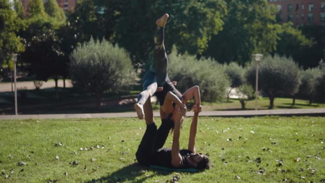 Beautiful-couple-practicing-acro-yoga-in-the-morning