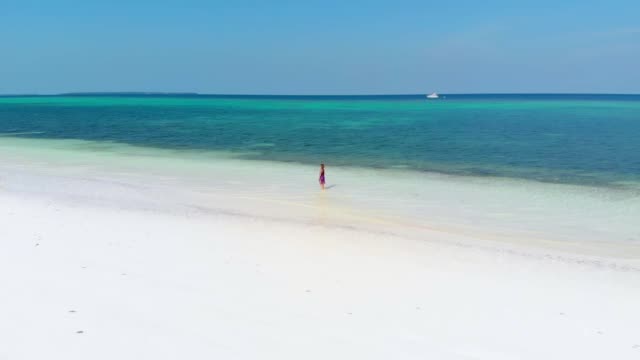 Aerial-slow-motion:-woman-walking-on-tropical-beach,-scenic-turquoise-water-and-white-sand,-Pasir-Panjang-Kei-Island,-Moluccas,-Indonesia,-paradise-travel-destination