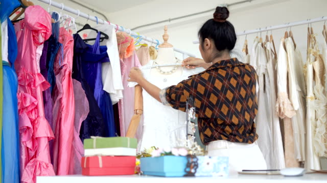 Asiatische-Frauen-Textilarbeiterinnen-messen-die-Länge-des-Hemdes,-die-im-Shop-Stoff-genäht-wird.