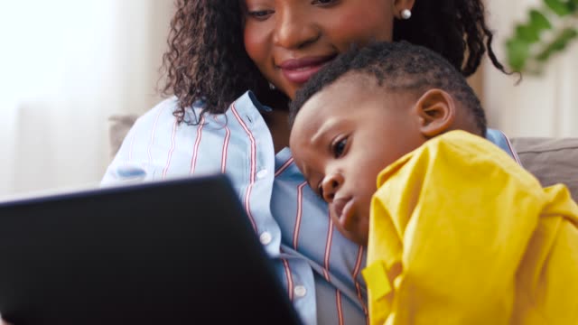 madre-usando-Tablet-PC-con-bebé-hijo-en-casa