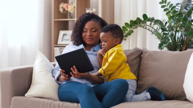 Mutter-mit-Tablet-PC-mit-Baby-Sohn-zu-Hause