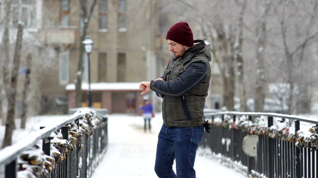 Young-man-waiting-for-someone-in-the-winter-city
