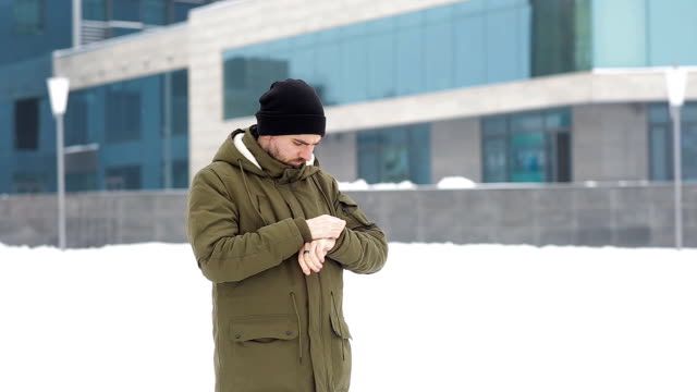 Young-man-waiting-for-someone-in-the-winter-city
