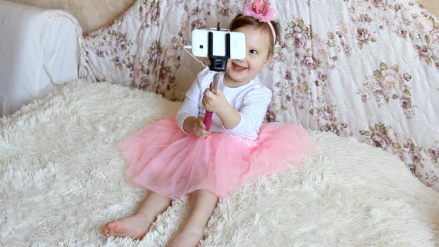 Ein-kleine-schöne-lustige-Mädchen-fotografiert-Selfie-am-Telefon