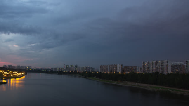 Cityscape-with-river-traffic-and-movement-of-the-clouds-at-dusk