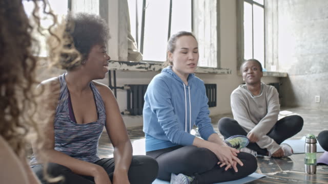 Fröhliche-Frauen-im-Chat-vor-der-Yogastunde
